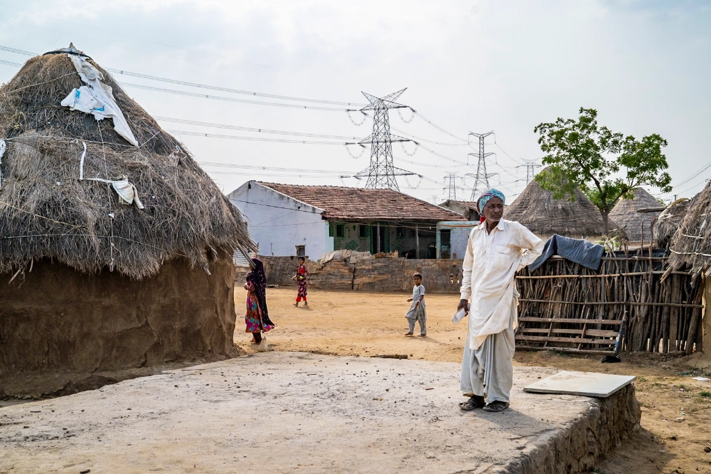 Ramzan stands in Raheemvandh settlements, where he lives close to the Khirasara solar park owned by Adani