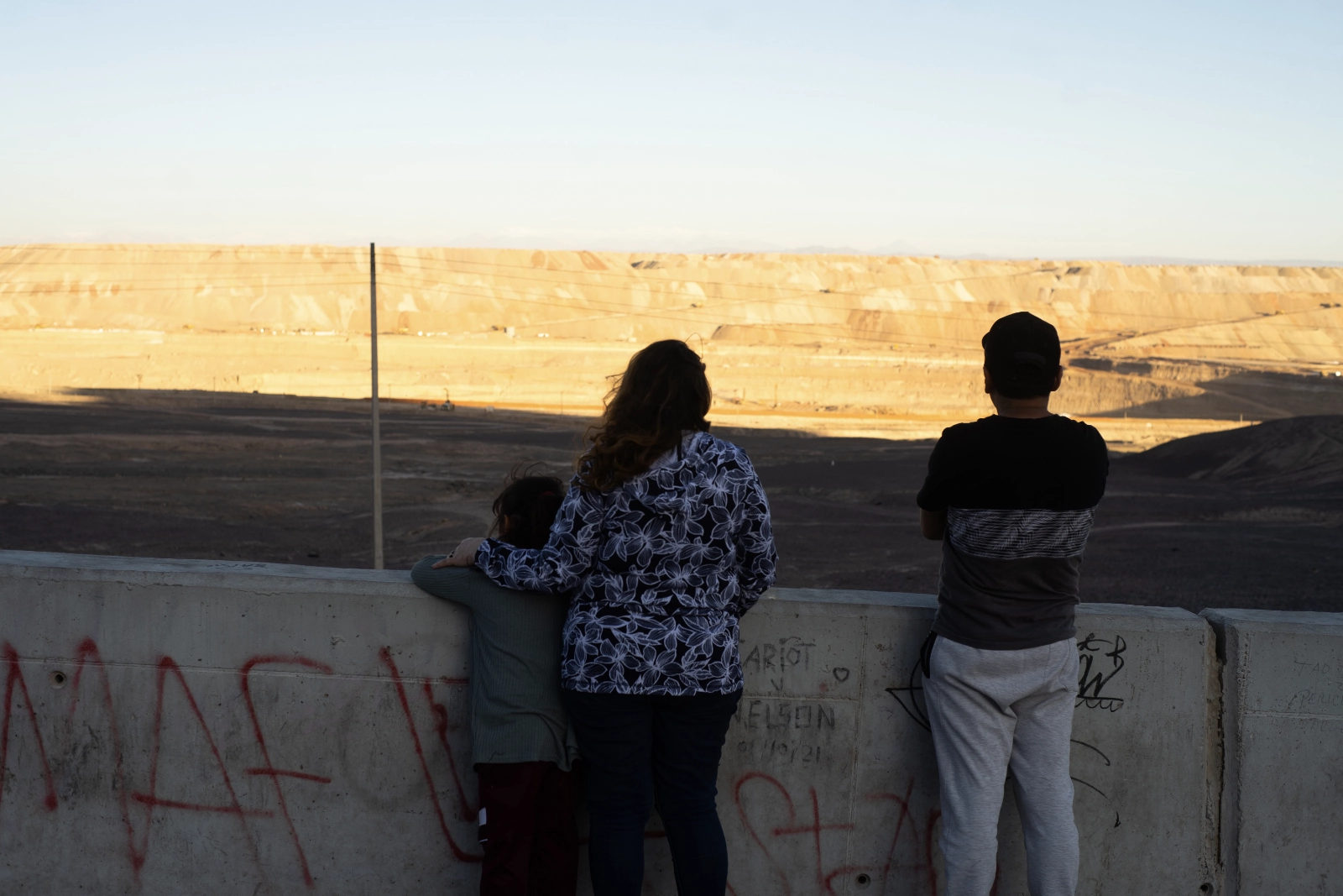 Isabel, her grandmother Aurelia Domínguez and her husband Calef look over the Ministro Hales copper mine