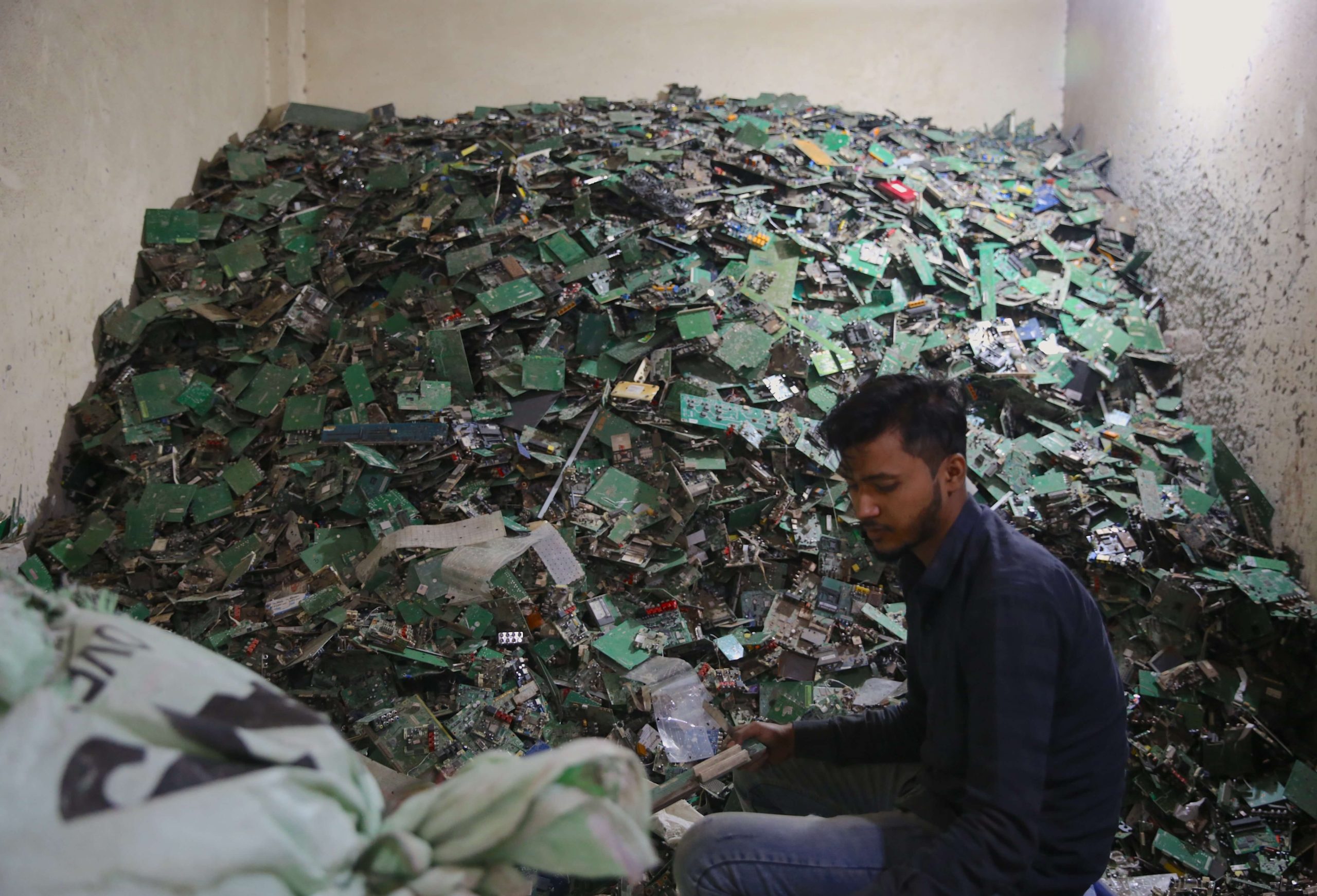 A man breaks down circuit boards to separate metals like copper from plastic